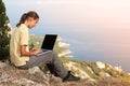 Girl working with laptop on mountain