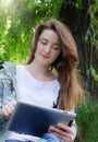 Girl working on a tablet in the park Royalty Free Stock Photo