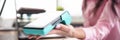 Girl in workplace holds banking mobile device