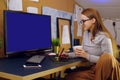 Girl works at home, graphic tablet, girl looks at a computer, green screen.