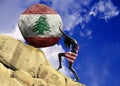 The girl, wrapped in the flag of united states, raises a stone to the top in the form of a silhouette of the flag of Lebanon