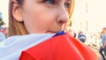 Girl wrapped in national flag standing among crowd, election campaign, politics