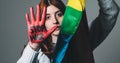 Girl wrapped in the peace flag raises her red hand that says stop war Royalty Free Stock Photo