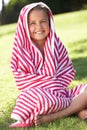 Girl Wrapped In Towel Sitting In Garden