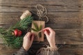 Girl wrapping christmas gift. Woman`s hands holding decorated gi