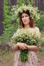 Girl with a wreath of daisies on her head and a bouquet in her hands Royalty Free Stock Photo