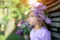 A girl with a wreath of lilac on her head looks away, pursing her lip. Royalty Free Stock Photo
