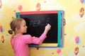 The girl writes on a blackboard a word the peace