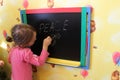 Girl writes on a blackboard a word the peace