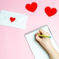 Girl writes a love letter. Valentines day concept. Greeting valentine card. Declaration of love. Wedding invitation. Red hearts. Royalty Free Stock Photo