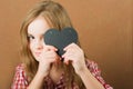 The girl writes a love message on Valentine`s Day. Baby with heart close-up and copy space. Children`s hands write a love message