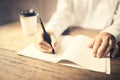 Girl writes in Notepad on a wooden desk with a cup of coffee Royalty Free Stock Photo