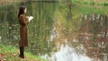 Girl Writes Standing By The Lake