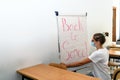 Girl writing back to school on whiteboard wearing medical mask at school, back to school during Covid-19 new normal Royalty Free Stock Photo