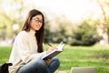 Girl writing in diary, sitting in modern parkland Royalty Free Stock Photo