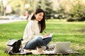 Girl writing in diary, sitting in parkland near university Royalty Free Stock Photo