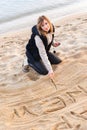 Girl Writing New Year in Sand Royalty Free Stock Photo