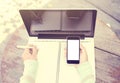 Girl writing in a notebook with a cell phone and a laptop Royalty Free Stock Photo