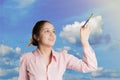 The girl is writing in the sky with a brush