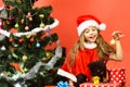 Girl in xmas hat plays with puppies holding golden ball. Royalty Free Stock Photo