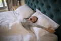 Girl yawning while stretching her arms in bed Royalty Free Stock Photo