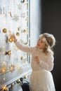 Girl of 8-9 years with delight admires gold Christmas-tree decorations. Royalty Free Stock Photo