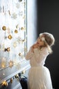 Girl of 8-9 years with delight admires gold Christmas-tree decorations. Royalty Free Stock Photo