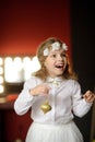 Girl of 8-9 years with delight admires gold Christmas-tree decorations. Royalty Free Stock Photo