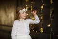 Girl of 8-9 years with delight admires gold Christmas-tree decorations. Royalty Free Stock Photo