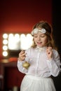 Girl of 8-9 years with delight admires gold Christmas-tree decorations. Royalty Free Stock Photo