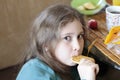 Girl 10 years old eating cookies. Bright expressive look, portrait in soft focus blur background.