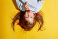 Girl 6 years old on a yellow background. Blue eyes and long hair. Holding a flower in his hands. Tenderness and a happy