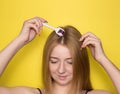 Girl on a yellow background with a mesoroller. Mesotherapy for hair and scalp. Cosmetology, hair and body care Royalty Free Stock Photo