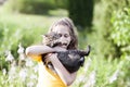 Girl in yellow dress holding lovely cat in her hands. Child and pet outdoors in summer day Royalty Free Stock Photo