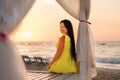 A girl in a yellow dress with long hair meets dawn