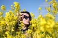 Girl and yellow flowers of rapeseed. Oilseed plant. Travel outside the city. Summer sunny weather Royalty Free Stock Photo