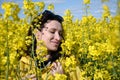 Girl and yellow flowers of rapeseed. Oilseed plant. Travel outside the city. Summer sunny weather Royalty Free Stock Photo