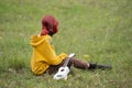 A girl in a yellow hoodie with red hair has a white ukulele.