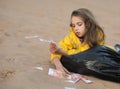 Girl in a yellow jacket lies on a bag of Russian money and holds notes