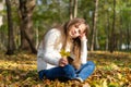 Girl with yellow leaves in autumn city park. Cute little blond child outdoors. Happy childhood Royalty Free Stock Photo