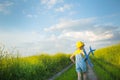 Girl in a yellow panama hat launches a toy plane into the field. Summer time, happy childhood, dreams and carelessness. Air tour