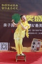 Girl in yellow performance fan dance on small bamboo stool
