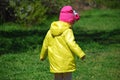 A girl in a yellow raincoat walking in the forest. Royalty Free Stock Photo