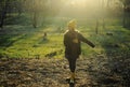 A girl in a yellow rubber boots walks through the forest. Travel concept with children. Autumn in the forest. Royalty Free Stock Photo