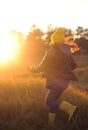 A girl in a yellow rubber boots walks through the forest. Travel concept with children. Autumn in the forest. Royalty Free Stock Photo