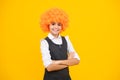 Girl with yellow wig. Funny child wearing orange curly wig hair, summer fun. Happy girl face, positive and smiling Royalty Free Stock Photo