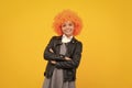 Girl with yellow wig. Funny child wearing orange curly wig hair, summer fun. Happy girl face, positive and smiling Royalty Free Stock Photo