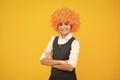 Girl with yellow wig. Funny child wearing orange curly wig hair, summer fun. Happy girl face, positive and smiling Royalty Free Stock Photo
