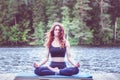 Girl in a yoga pose on the lake. Lotus position , Padmasana. The concept of appeasement, healthy lifestyle