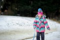 Girl of younger school age on walk in winter park about slope for toboggans.